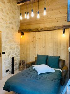 a bedroom with a blue bed with a stone wall at Chalet Annecy 200m lac, plage & montagnes in Annecy