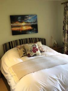 uma cama branca com duas almofadas em cima em Field's Edge em Swinderby