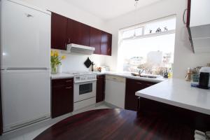 cocina con electrodomésticos blancos y ventana grande en Sunny Reykjavik Apartment, en Reikiavik