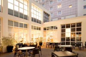 a large building with tables and chairs in the courtyard at Novotel Lille Centre Grand Place in Lille