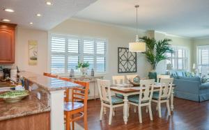 a kitchen and living room with a table and chairs at Malibu 501 by Ocean Properties in New Smyrna Beach