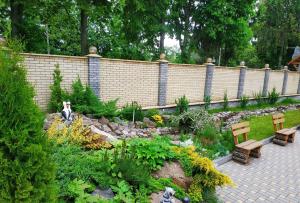 een tuin met twee banken en een steunmuur bij Zhyttedar in Ulanov