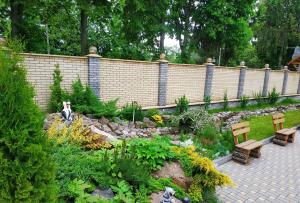 a garden with two benches and a retaining wall at Zhyttedar in Ulanov