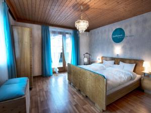 フューゲンにあるHaus Sonneneckのベッドルーム1室(青いカーテン付きの大型ベッド1台付)