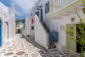 a street with white buildings and a green door at Traditional stonebuilt house in Kampos Paros
