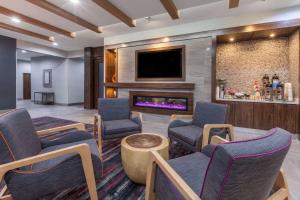 a waiting room with chairs and a fireplace at La Quinta by Wyndham Houston East at Sheldon Rd in Channelview