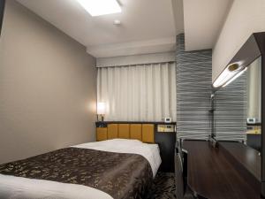 ein kleines Schlafzimmer mit einem Bett und einem Fenster in der Unterkunft APA Hotel Nagoya Ekimae Kita in Nagoya