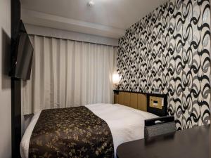 a hotel room with a bed and a table at APA Hotel Nagoya Ekimae Kita in Nagoya