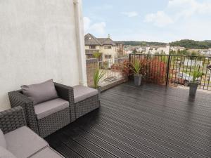a balcony with a couch and chairs on a balcony at Castle View in Conwy