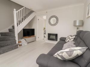 a living room with a couch and a staircase at Castle View in Conwy
