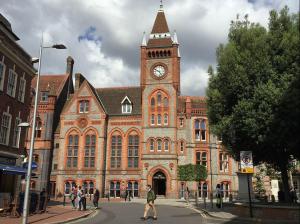 a large brick building with a clock tower at Morden Central Self Contained Flat by CozyNest in Reading