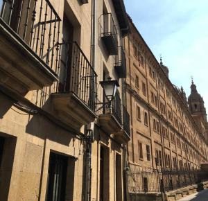 un edificio con balcones al lado de una calle en Apartamento Serranos Centro Histórico, en Salamanca