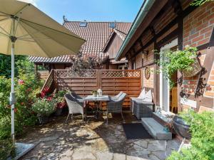 eine Terrasse mit einem Tisch, Stühlen und einem Sonnenschirm in der Unterkunft Picturesque Holiday Home in Kritzmow with Garden in Kritzmow