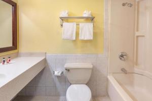 a bathroom with a toilet and a tub and a sink at Days Inn by Wyndham Nanuet / Spring Valley in Nanuet