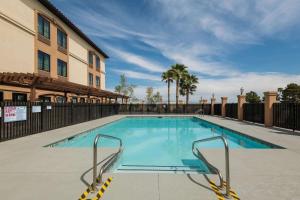 a swimming pool at a hotel with a building and palm trees at La Quinta by Wyndham Las Vegas Airport South in Las Vegas