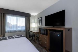um quarto de hotel com uma cama e uma televisão de ecrã plano em La Quinta by Wyndham Anchorage Airport em Anchorage