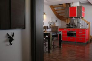 a kitchen with red cabinets and a table in a room at Maisonette Deluxe by fewo-amperland in Olching