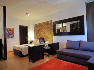 1 dormitorio con cama, escritorio y sofá en Casa Nacho by Delabra Apartments, en Oviedo