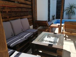 a patio with a couch and a table and a pool at Apartment Rustica Zadar with exclusive use of the pool-ground floor in Zadar