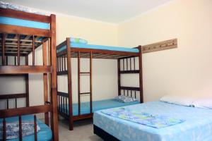 two bunk beds in a room with a bed at Pousada Jolly Roger in Bertioga