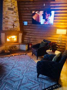 ein Wohnzimmer mit einem Kamin und einem TV in der Unterkunft Gostynnyi Dvir VIP HOUSE in Myhowe
