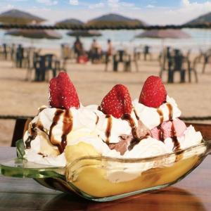 a banana split with whipped cream and strawberries on the beach at Pousada Jolly Roger in Bertioga