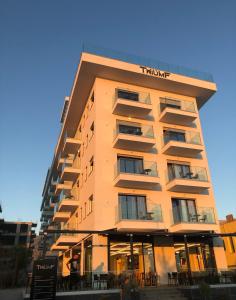 a tall building with a hotel sign on it at Hotel Bar Restaurant Triumf Shengjin in Shëngjin