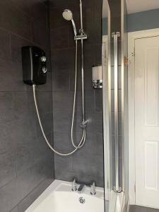 a shower in a bathroom with a sink at No 52 - Apartment with Lounge and Dining Area - No kitchen in Ullapool