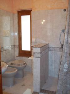 a bathroom with a toilet and a sink and a shower at La casa di Mariù in Furnari