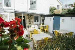 an outdoor patio with tables and chairs and a building at Finest Retreats - Godolphin Cross B&B - King Room in Carleen