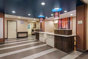 a hotel lobby with a reception counter and blue lights at La Quinta by Wyndham Jamestown in Jamestown