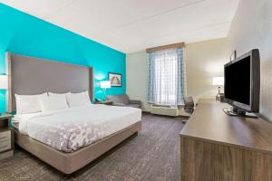 a hotel room with a bed and a flat screen tv at La Quinta by Wyndham Jamestown in Jamestown