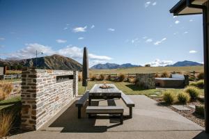 瓦纳卡Bull Ridge Retreat - Sleeps 6 - Spa Pool - Sauna - Mountain Views的一个带桌子和沙发的庭院,享有山景。