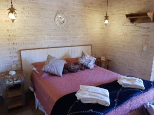 a bedroom with a bed with two towels on it at Pousada Canto do Sabiá in Monte Verde