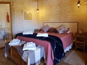 um quarto com uma cama com toalhas em Pousada Canto do Sabiá em Monte Verde