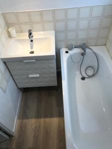 a bathroom with a sink and a bath tub next to a toilet at Chez Edwige à Cabourg thalasso plage WIFI in Cabourg +26 photos
