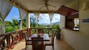 a dining room with a table and chairs on a balcony at Villa Touloulou in English Harbour Town