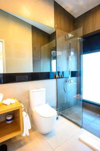 a bathroom with a toilet and a glass shower at Loloata Island Resort in Loloata Island