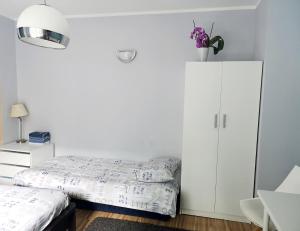 1 dormitorio con 1 cama y armario blanco en Apartament Legionów 55, en Gdynia