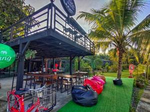 un restaurante con mesas y sillas y un balcón en Baantia Chomtawan, en Suratthani