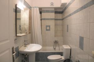 a bathroom with a sink and a toilet and a tub at Kalamaki Plaza Apartments in Kalamaki
