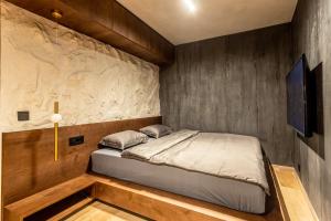 a bed in a room with a wall at Bella Roe Premium Apartments in Belgrade