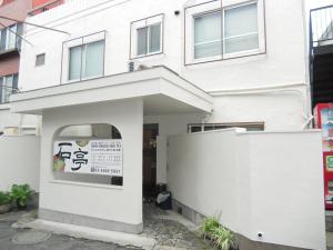 un bâtiment blanc avec un panneau devant lui dans l'établissement Shin Okubo Sekitei, à Tokyo