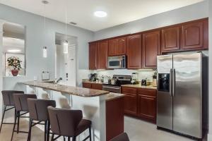 a kitchen with wooden cabinets and a stainless steel refrigerator at Vista Cay in Orlando
