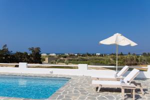 a pool with two lounge chairs and an umbrella at ILI Villa in Plaka