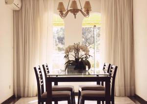 a dining room table with chairs and a vase of flowers at Mansão Morumbi 91 in Sao Paulo