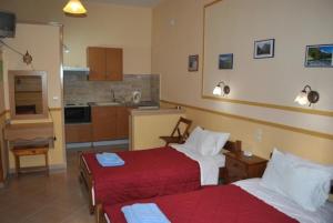 a hotel room with two beds and a kitchen at Stelios Studios in Megali Ammos
