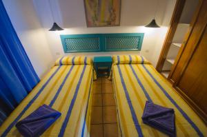 two beds in a room with blue and yellow stripes at Apartamentos Agua Marina in Puerto del Carmen