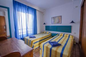 a hotel room with two beds and a table at Apartamentos Agua Marina in Puerto del Carmen
