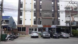 a parking lot with cars parked in front of a building at Sena House Lamlukka Klong2 in Pathum Thani